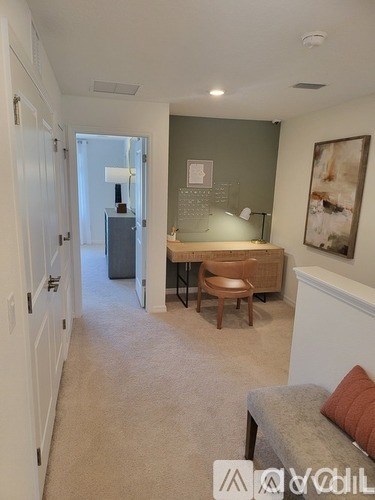 A living room with a grey couch and a wooden chair.