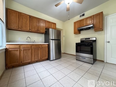 A kitchen with wooden cabinets and a stainless steel refrigerator.
