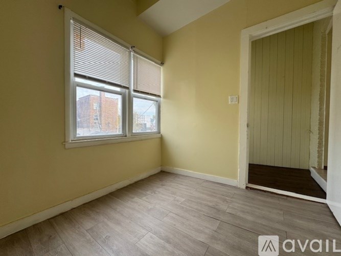 A room with a window and a door is available for rent.