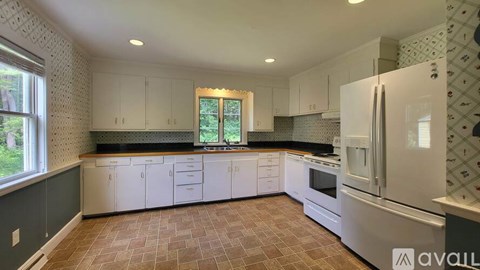 A kitchen with white cabinets and a refrigerator.