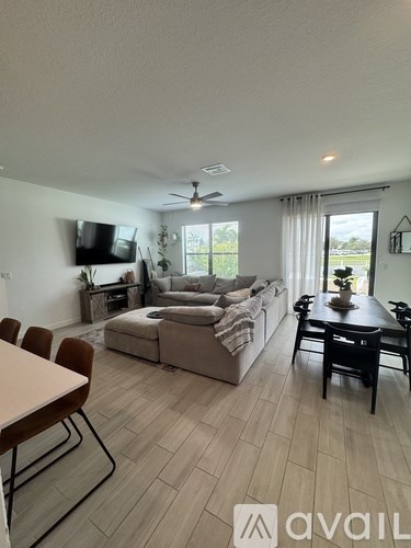 A living room with a couch, chairs, and a television.