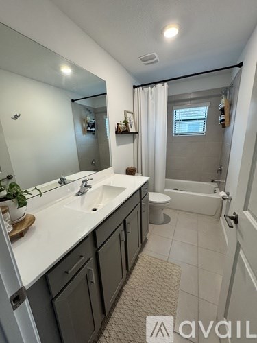A bathroom with a sink, mirror, and bathtub.