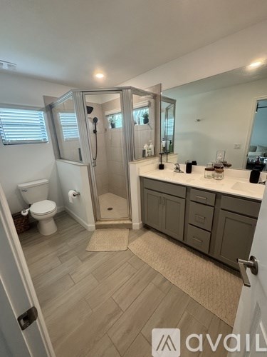 A bathroom with a toilet, sink, and shower area.