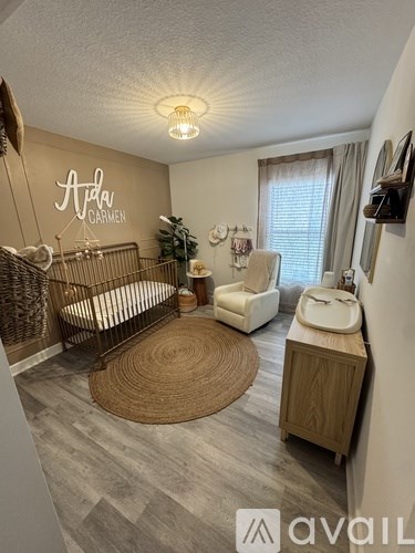 A baby's room with a crib, chair, and a rug.
