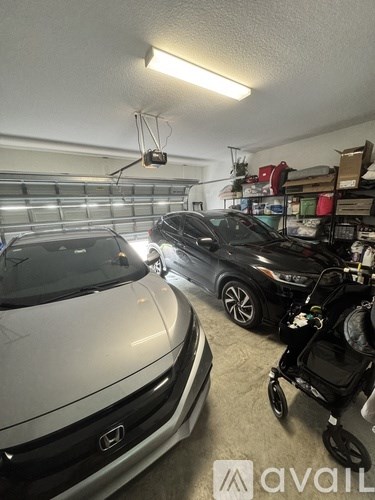 A garage with a white car and a black car parked inside.