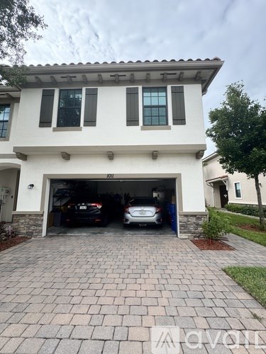 A two-car garage is attached to a white house.