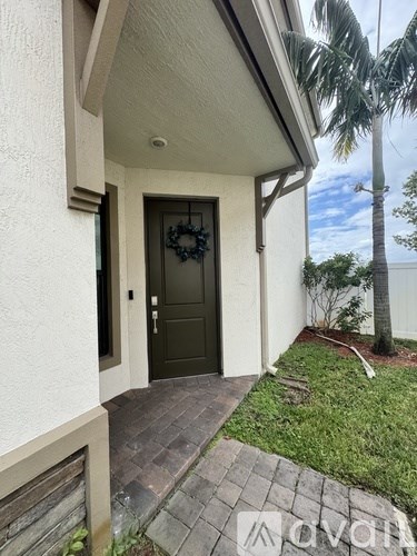 A house with a dark brown door and a wreath on it.