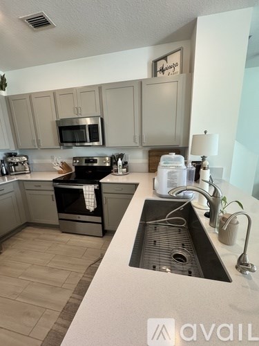 A kitchen with a sink and a fridge.