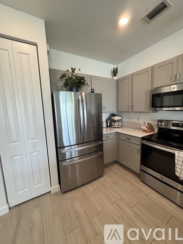 A kitchen with a stainless steel refrigerator, microwave, and oven.