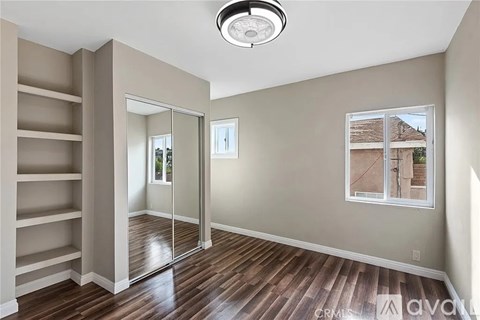 A room with a sliding glass door and wooden floors.