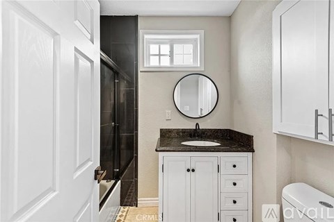 A bathroom with a sink, mirror, and cabinets.