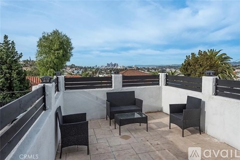 A balcony with black furniture and a view of the city.
