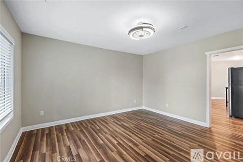 A room with wooden flooring and a ceiling light fixture.