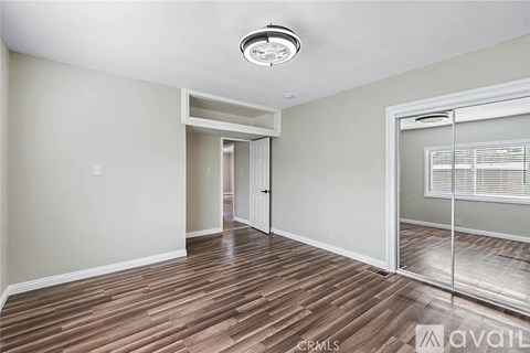 A spacious room with wood flooring and a ceiling light.