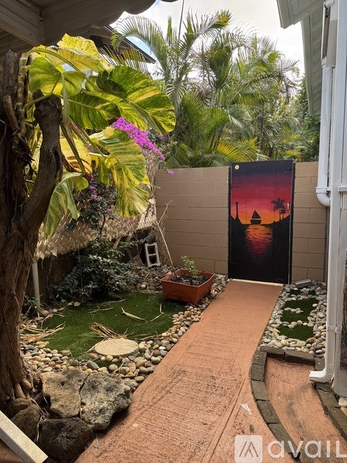 A small garden with a wooden path and a poster on the wall.