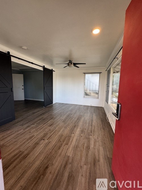 A room with wooden flooring and a ceiling fan.