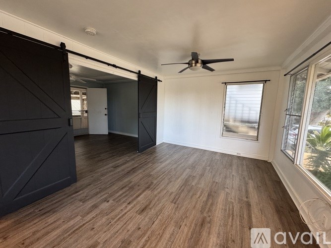A room with wooden flooring and a ceiling fan.