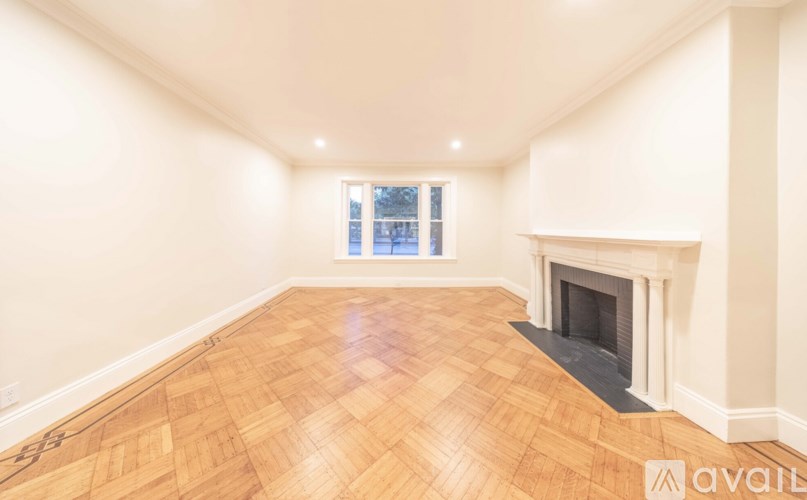 A spacious room with a fireplace and a window.