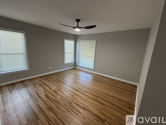 A room with wooden flooring and a ceiling fan.