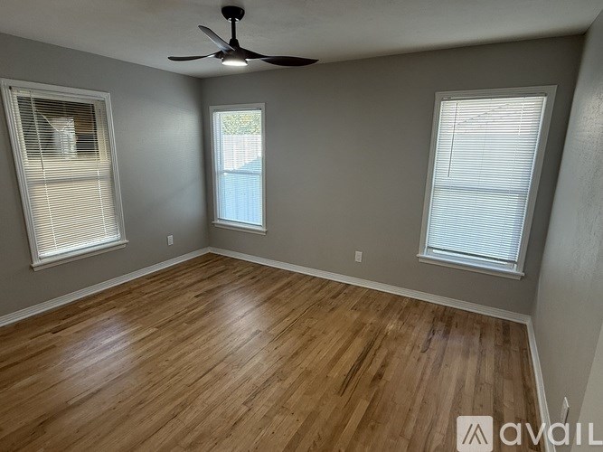 A room with wooden flooring and a ceiling fan.