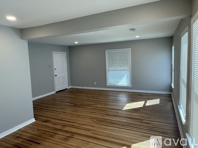 A room with wooden flooring and a window.