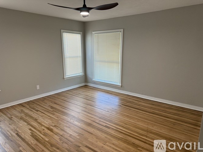 A room with wooden flooring and a ceiling fan.