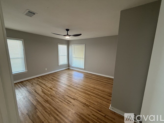 A room with wooden flooring and a ceiling fan.