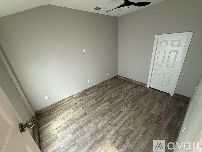 A room with wooden flooring and a ceiling fan.
