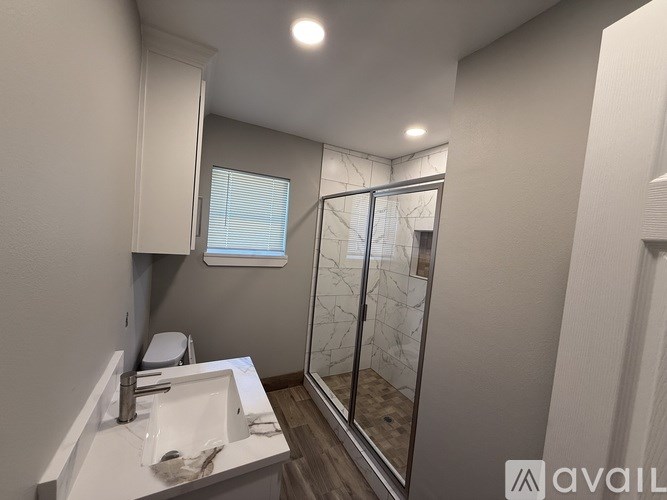 A bathroom with a sink, mirror, and shower.