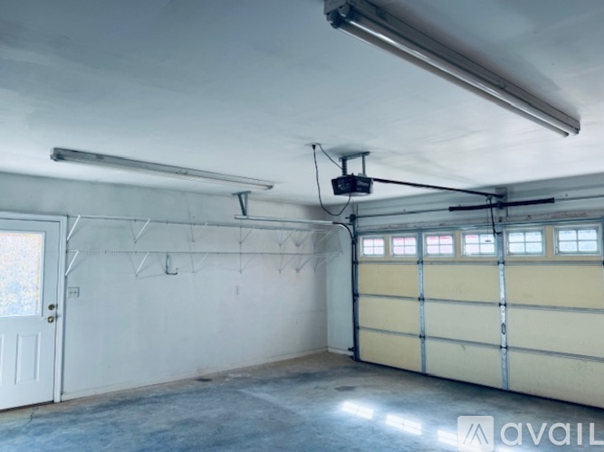 A spacious garage with a white door and a yellow garage door.