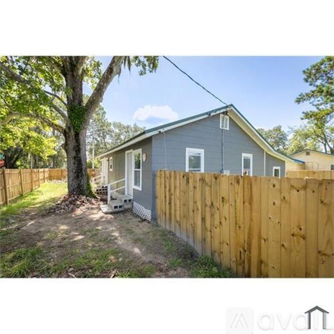 A small house with a wooden fence in front of it.