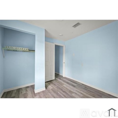 A room with a white door and a shelf with a green item on it.