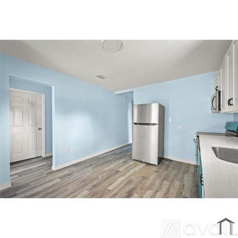 A kitchen with a white fridge and a white door.