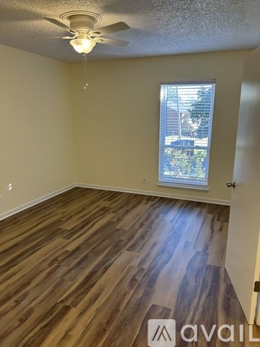 A room with wooden flooring and a ceiling fan.