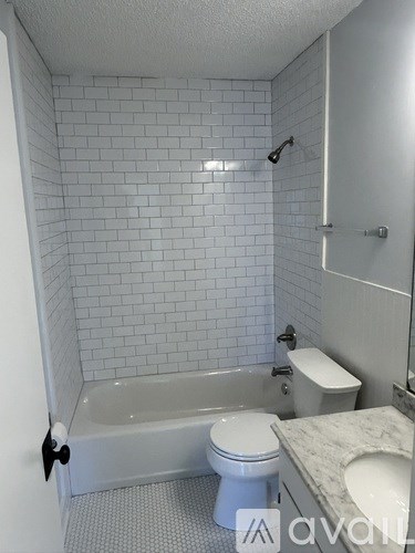 A white bathroom with a toilet, sink, and bathtub.