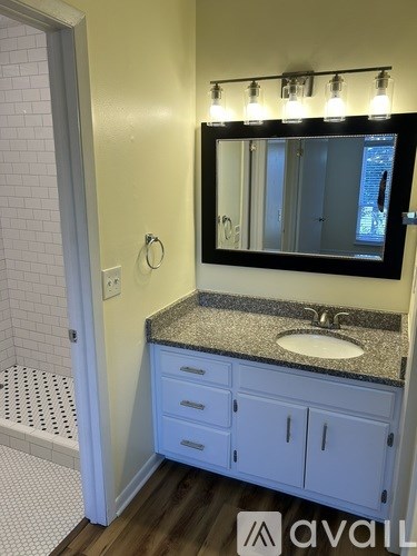 A bathroom with a sink, mirror, and cabinets.