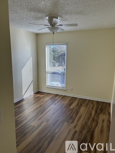 A room with wooden flooring and a ceiling fan.