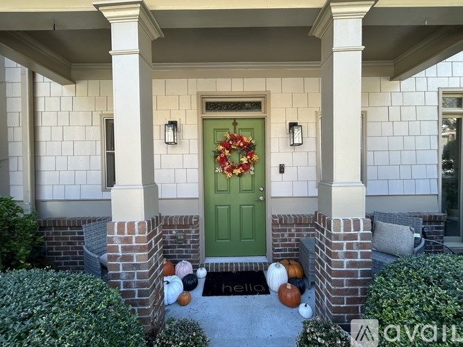 A house entrance with a green door and a wreath on it.