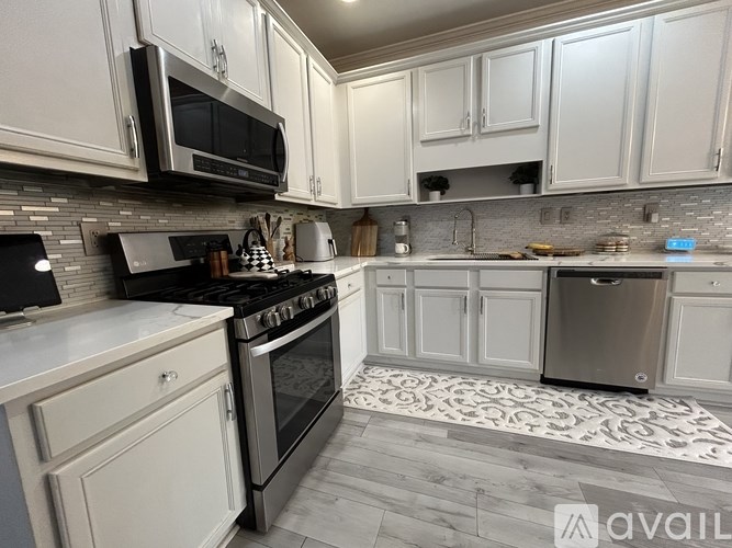 A kitchen with white cabinets and a black stove top oven.