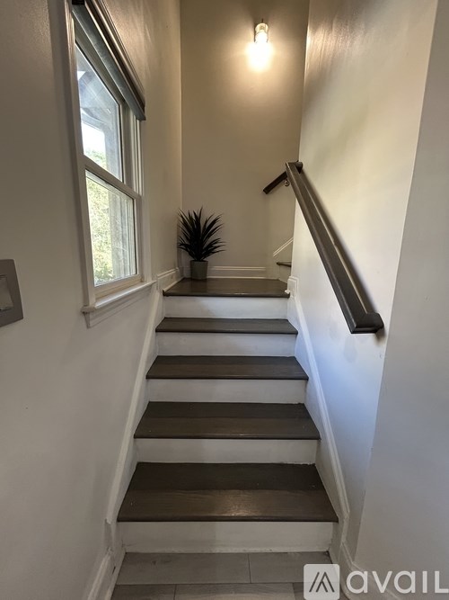 A staircase with wooden steps and a metal handrail.
