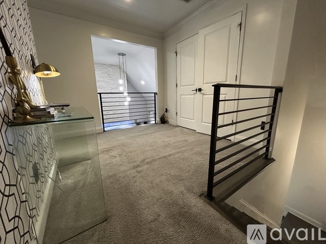 A room with a glass table, a lamp, and a metal railing.
