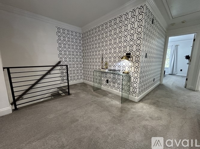 A room with a hexagonal patterned wallpaper and a black metal railing.