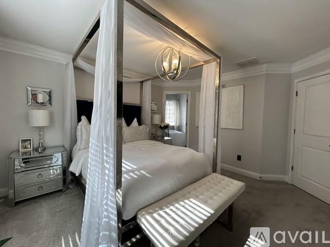 A bedroom with a canopy bed and a bench.