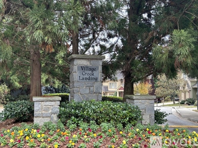 A sign that says Village Creek Landing in front of some trees.
