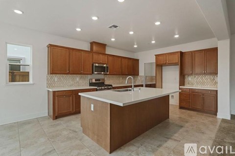 A kitchen with brown cabinets and a central island.