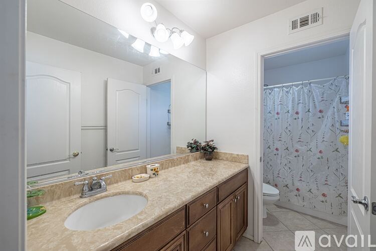 A bathroom with a sink, mirror, and shower.