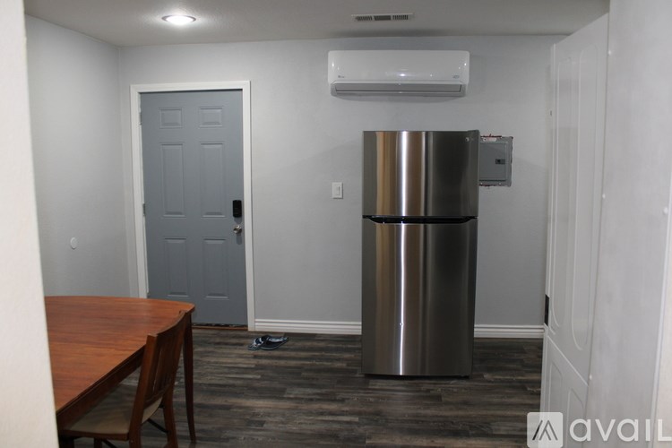 A kitchen with a stainless steel refrigerator and a wooden table.