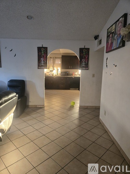 A living room with a couch and a picture of two people on the wall.