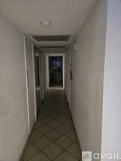 A long hallway with tiled floors and white walls.