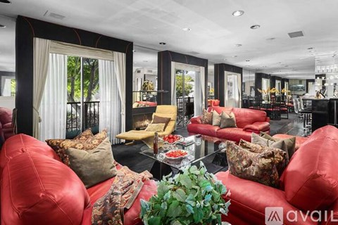 A living room with red couches and a glass table.